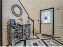 Elegant foyer with patterned tile flooring, ornate console table, and staircase at 2587 Alvecot Cir, Atlanta, GA 30339