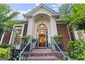 Elegant front entrance featuring brick steps, black railing, and an arched transom window at 107 Calloway Xing, Peachtree City, GA 30269