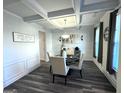 Formal dining area featuring coffered ceiling, wainscoting, and modern chandelier at 5257 Shorthorn Way, Powder Springs, GA 30127