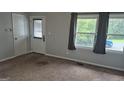 Bright living room with neutral walls, plush carpeting, and natural light from large windows at 250 Jonesboro Rd, Jonesboro, GA 30236