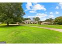 Sprawling lawn and circular driveway lead to this lovely home and detached garage at 115 Fernway Dr, Fayetteville, GA 30214