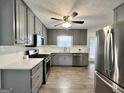 Modern kitchen featuring gray cabinets, stainless steel appliances, granite counters, and new flooring at 116 Cardell Farms Rd, Locust Grove, GA 30248