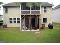 View of a multi-level deck with a seating area on a well-maintained lawn, adding outdoor living space at 6131 Sparkling Cove Ln, Buford, GA 30518