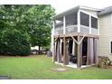 View of the deck with screening and curtains, providing privacy and shade in the landscaped backyard at 6131 Sparkling Cove Ln, Buford, GA 30518