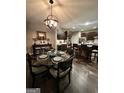 Elegant dining room with stylish chandelier and seamless flow into the kitchen at 6131 Sparkling Cove Ln, Buford, GA 30518
