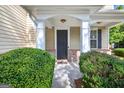 Inviting front porch with stately columns and manicured greenery at 6131 Sparkling Cove Ln, Buford, GA 30518