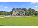 Beautifully landscaped front yard of a two-story home with lush greenery and a long driveway at 110 Sunflower St, Tyrone, GA 30290