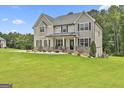 Two-story home with rocking chairs on the front porch and a well-maintained lawn at 110 Sunflower St, Tyrone, GA 30290