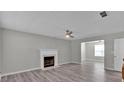 Open-concept living room featuring a fireplace, ceiling fan, and hard surface floors at 7770 Hana Court Ct, Jonesboro, GA 30236