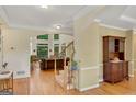 Inviting foyer featuring hardwood floors, staircase, and an open view into the living room with large windows at 3245 Bywater Trl, Roswell, GA 30075