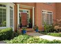 Charming front entrance with brick facade, decorative columns, and lush landscaping adding curb appeal at 3245 Bywater Trl, Roswell, GA 30075