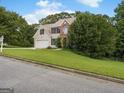 Attractive two-story home with a two-car garage nestled among mature trees on a sunny day at 942 Marta Crane Dr, Lawrenceville, GA 30045