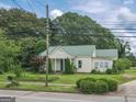 Charming home exhibits a well-maintained lawn, beautiful landscaping, and mature trees, enhancing the overall curb appeal at 178 S Old Highway 27, Roopville, GA 30170