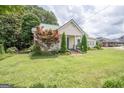 Charming home exhibits a well-maintained lawn, beautiful landscaping, and mature trees, enhancing the overall curb appeal at 178 S Old Highway 27, Roopville, GA 30170