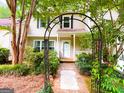 Charming home with an arched trellis, featuring lush landscaping and a welcoming front entrance at 3150 Stratford Green Pl, Avondale Estates, GA 30002