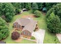 Aerial view of brick home with manicured lawn, mature trees, and long driveway at 280 Ridgemont Dr, Fayetteville, GA 30215