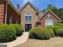 Inviting brick and stone home featuring a prominent arched window and double front doors at 1209 Persimmon Way, Mcdonough, GA 30252