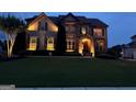 Charming two-story home with well-lit exterior and lush green lawn at twilight at 4425 Martel Dr, Cumming, GA 30040