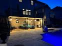 Backyard pool with an outdoor patio and deck above with outdoor lighting at 4425 Martel Dr, Cumming, GA 30040