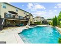 Backyard pool with a deck above and covered patio with furniture at 4425 Martel Dr, Cumming, GA 30040