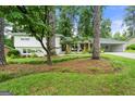 Charming exterior of home with lush landscaping and inviting front porch with wooded trees at 2944 Braithwood Ne Ct, Atlanta, GA 30345