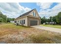 View of home from the side, showing brick facade, attached garage and a partially wooded lot at 501 Llewellyn Ct, Jenkinsburg, GA 30234
