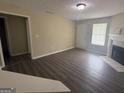 Open living room featuring wood floors, fireplace, and access to the front door at 756 Glenshire Ct, Riverdale, GA 30274