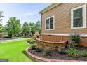 Beautiful backyard showcasing an outdoor stone fireplace, a half wall of stone, and a well-manicured lawn at 150 Campaign Trl, Fayetteville, GA 30214