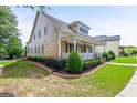 Attractive home featuring an expansive lawn with beautiful plantings and an inviting covered porch on the side at 150 Campaign Trl, Fayetteville, GA 30214