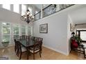 Elegant dining room showcasing a chandelier, large windows, and seating for eight around the table at 825 Chalet Hls, Mcdonough, GA 30253