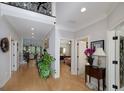 Bright hallway with hardwood floors, white trim, and views into other rooms of the house at 825 Chalet Hls, Mcdonough, GA 30253