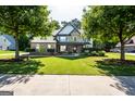Beautiful home exterior featuring a well-manicured lawn, stone accents, and mature trees at 145 Seawright Dr, Fayetteville, GA 30215