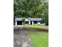 Charming ranch-style home with black two-car garage and surrounded by lush trees at 168 Park Ln, Dallas, GA 30157
