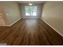 Bright living room with a large window and wood-look laminate flooring at 160 Odyssey Turn, Conyers, GA 30012