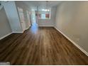 Bright living room featuring laminate flooring and access to other rooms at 160 Odyssey Turn, Conyers, GA 30012