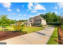 Sprawling two-story home boasting an expansive lawn and a lengthy driveway with ample parking at 150 Dean Dr, Tyrone, GA 30290