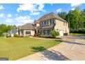 Beautifully landscaped front yard and long driveway leading to a luxurious two-story home with an attached garage at 150 Dean Dr, Tyrone, GA 30290