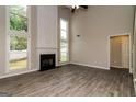 Bright living room with a fireplace, tall windows, and stylish wood-look tile flooring at 2801 Priestcliff Dr, Smyrna, GA 30080