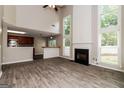 Open-concept living space with modern wood-look tile flooring, fireplace, and kitchen view at 2801 Priestcliff Dr, Smyrna, GA 30080