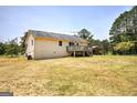 View of home's rear, showing back yard, deck, and carport in a well-maintained setting at 668 Spring Place Ne Rd, White, GA 30184