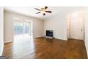 Living room features hardwood floors, a ceiling fan, fireplace, and access to a patio at 503 Countryside Se Pl, Smyrna, GA 30080