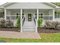 Welcoming front porch with columns, painted brick steps, black iron railings, and landscaped bushes at 306 Tyrone Rd, Fayetteville, GA 30214