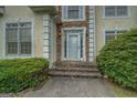 Close-up of the front entrance with stone steps and decorative trim at 235 Rustic Mill Ln, Fayetteville, GA 30214