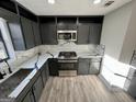 Modern kitchen with stainless steel appliances, gray cabinets and marble backsplash at 295 Lamden Ct, Lawrenceville, GA 30046