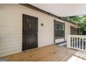 View of a front porch with a security door, wood decking, and neutral siding at 770 Four Winds Ln, Jonesboro, GA 30238