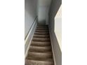 Carpeted staircase with white railing and neutral gray walls, leading to the upper level at 2756 Norfair Loop, Lithonia, GA 30038