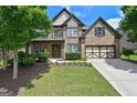 Stately brick home with manicured lawn, mature landscaping, and a two-car garage at 5825 Trailwood Ct, Suwanee, GA 30024