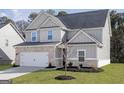 Attractive two-story home with grey siding, brick accents, and a neatly landscaped front yard at 3373 Arabian Farm Dr, Dacula, GA 30019