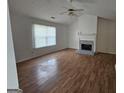 Inviting living room with fireplace, vaulted ceiling, and hardwood flooring at 10 Nicole Ct, Covington, GA 30016