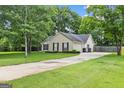 Suburban home featuring a long driveway leading to an attached garage with manicured front lawn at 615 Coan Dr, Locust Grove, GA 30248